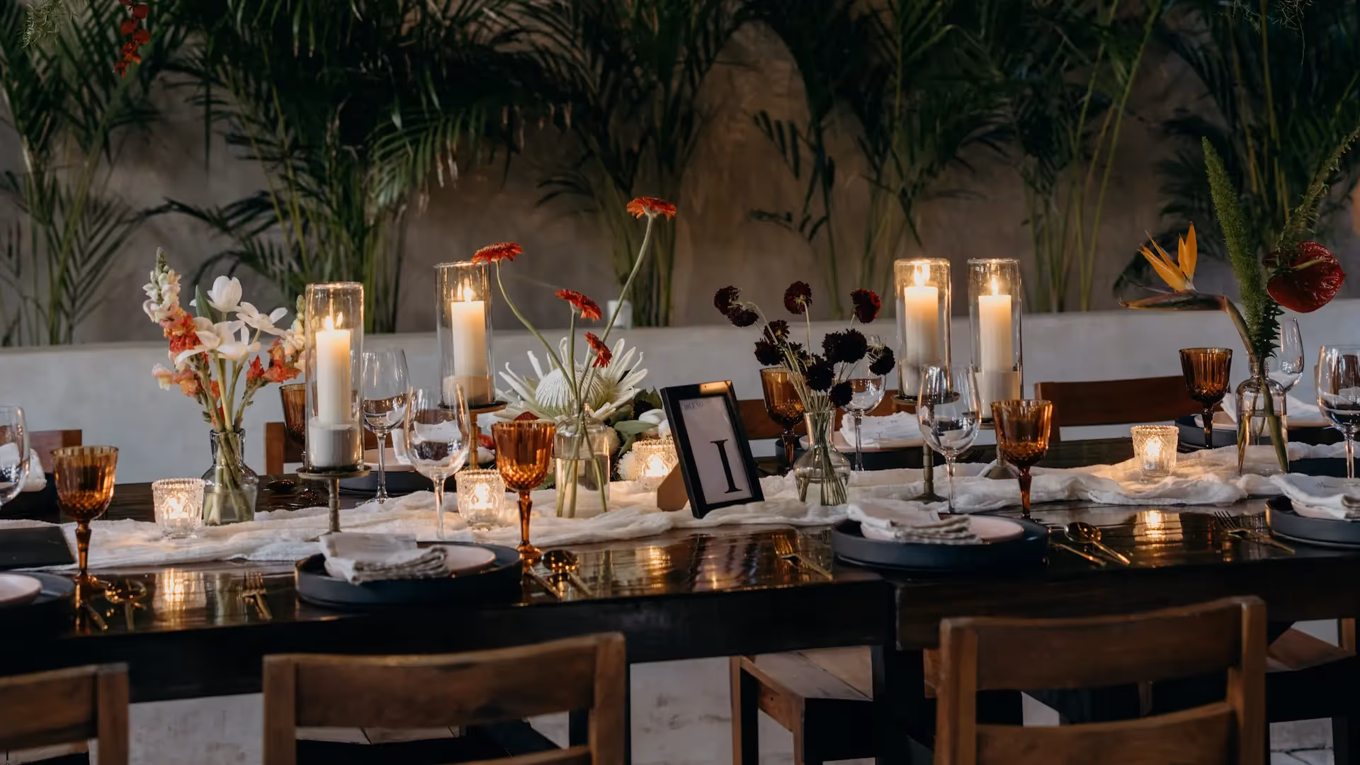 Elegante mesa de comedor con velas y flores tropicales para un evento privado en el hotel La Valise Tulum.