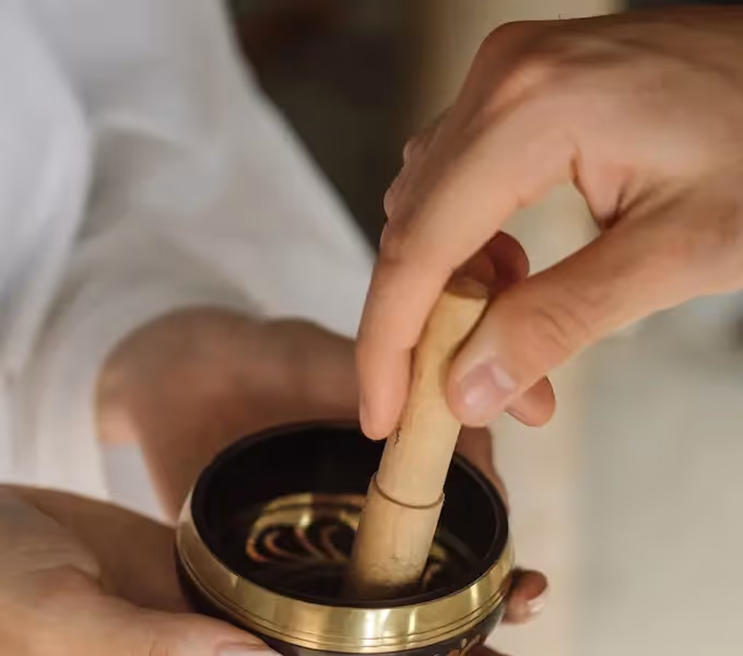 Joven sonriente aplicándose una máscara corporal de barro o arcilla en la playa del hotel La Valise Tulum.