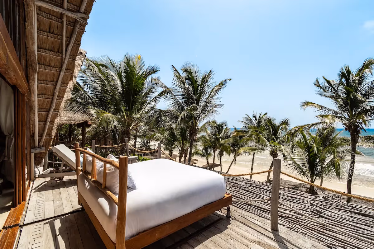 Luxury suite featuring an outdoor bed on a private balcony with stunning ocean views at La Valise Tulum Hotel.