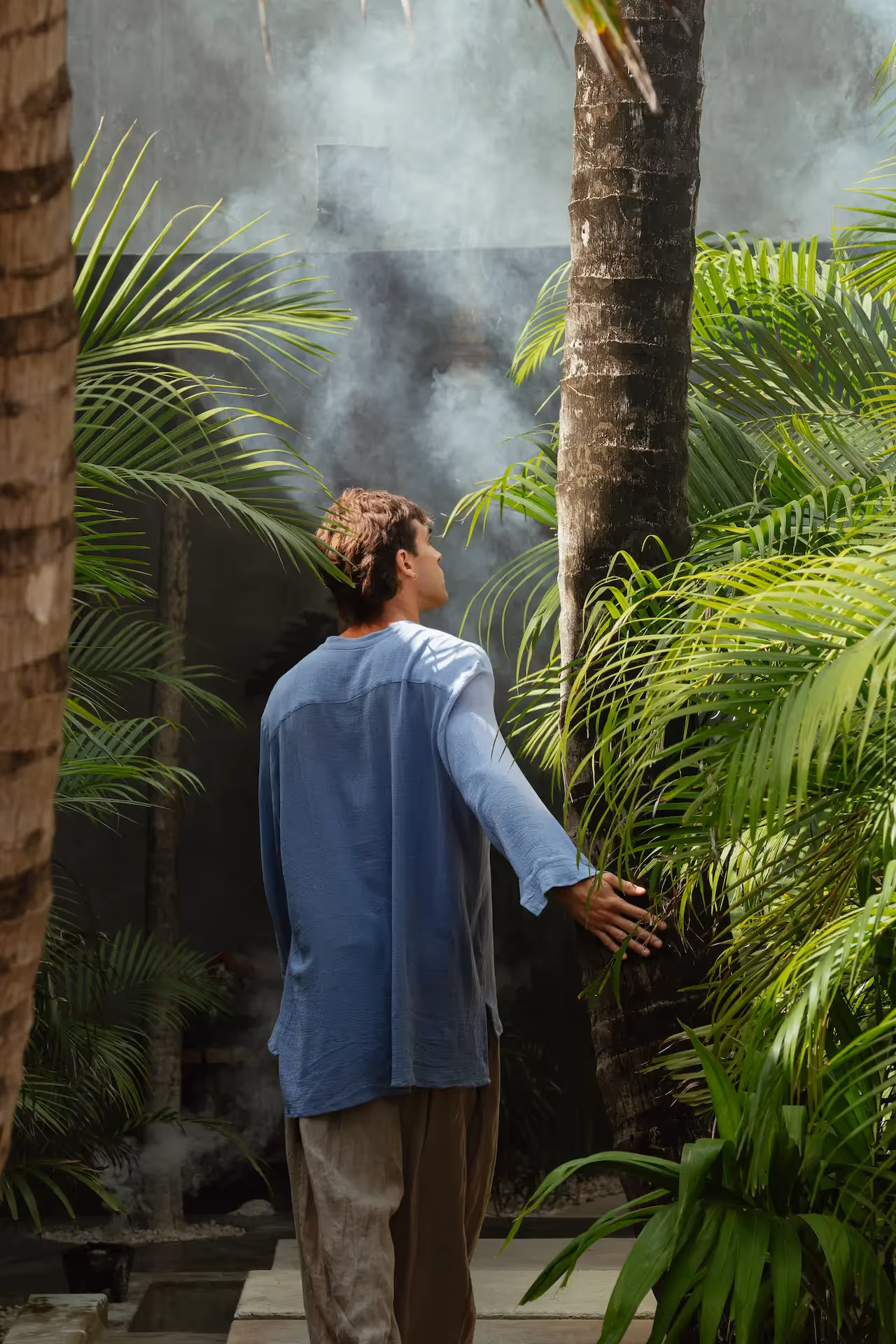 A guest enjoying the lush tropical gardens and palm trees at La Valise Tulum Hotel.