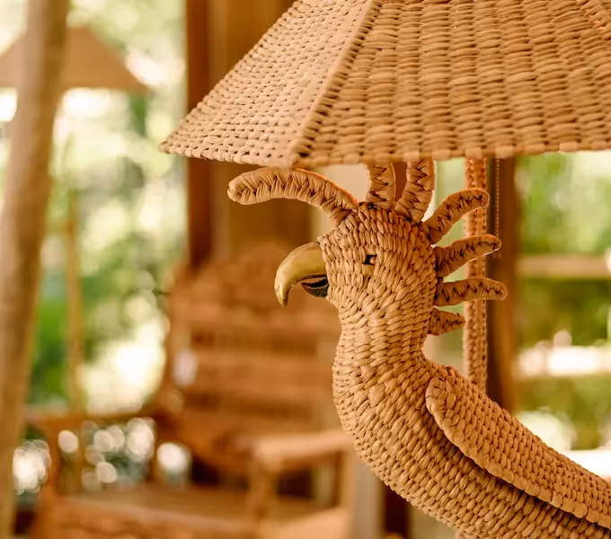 Close-up of a handcrafted wicker cockatoo, a signature bohemian decor piece at La Valise Tulum Hotel.