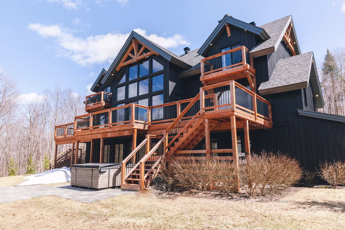 Façade du chalet L'Ours Noir avec grande terrasse en bois sur deux étages