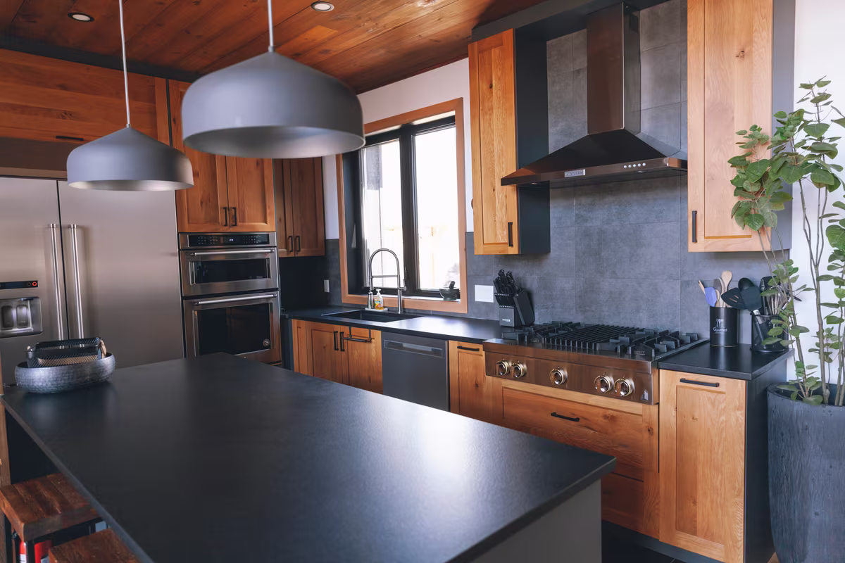 Cuisine du chalet L'Ours Noir avec îlot noir et armoires en bois