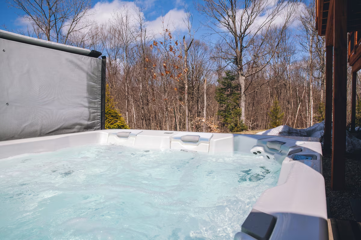 Spa privé sur la terrasse du chalet L'Ours Noir, vue sur la forêt