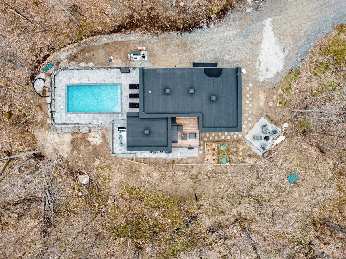 Vue aérienne du chalet LIV Tremblant et de sa piscine en forêt