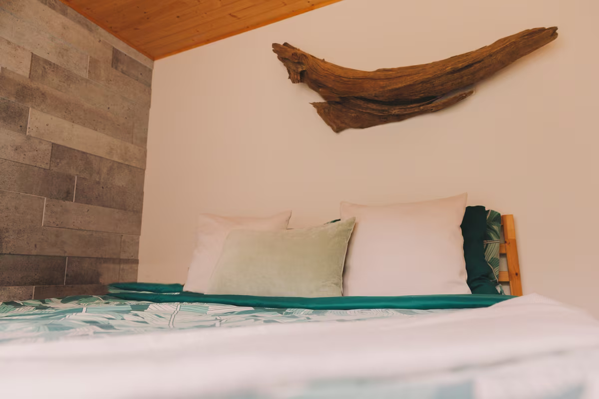 Chambre 3 du chalet Le Phoenix, lit double sous une sculpture de bois flotté