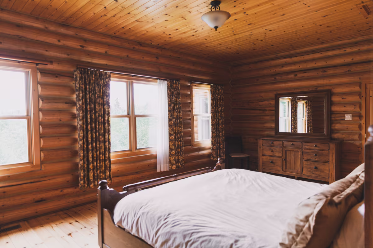 Chambre 1 du chalet Le Duc, lit King dans une pièce en bois rond