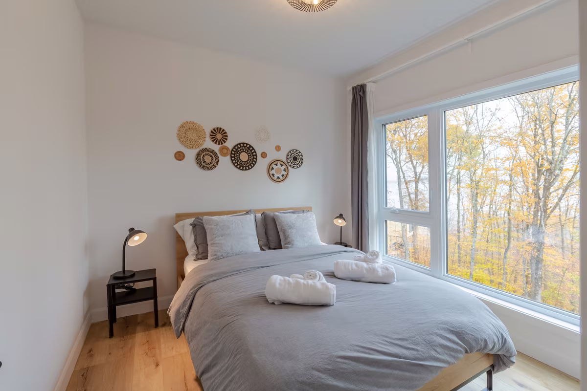 Chambre 3 du chalet LIV Tremblant, grand lit et décor mural en rotin