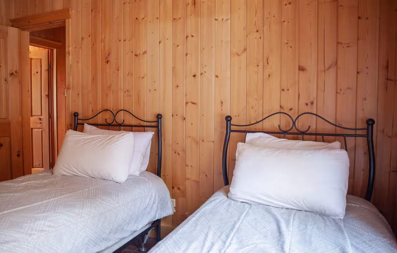 Chambre 4 du chalet Exécutif Plus, deux lits simples en fer forgé