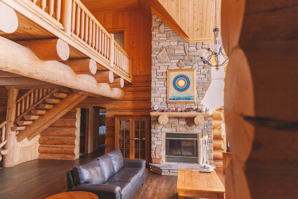 Grande pièce du chalet Exécutif Plus avec foyer en pierre et mezzanine