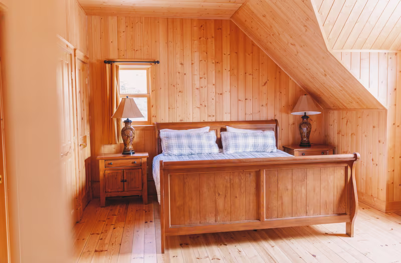 Chambre 2 du chalet Exécutif Plus, lit King en bois sous plafond en pente