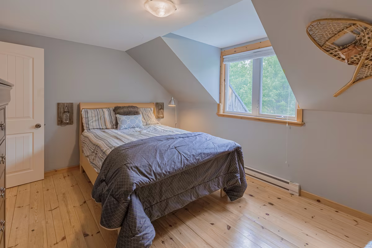 Chambre 2 du chalet Fox Lodge, grand lit sous plafond en pente
