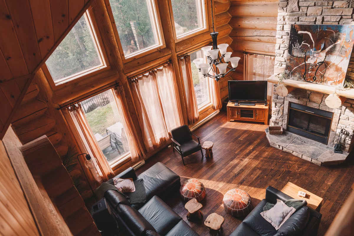 Grande pièce du chalet Élan Lodge #52 avec foyer en pierre et canapés en cuir