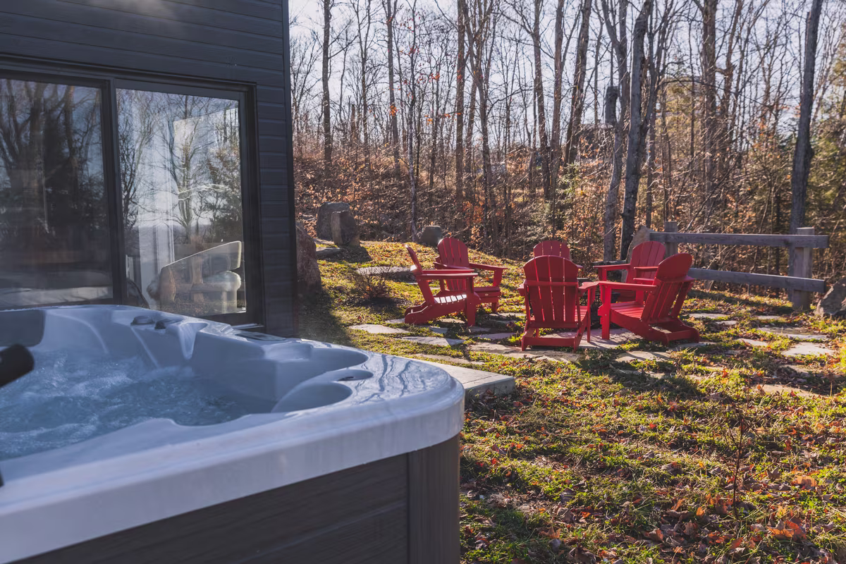 Spa privé du chalet Avala et foyer extérieur en forêt