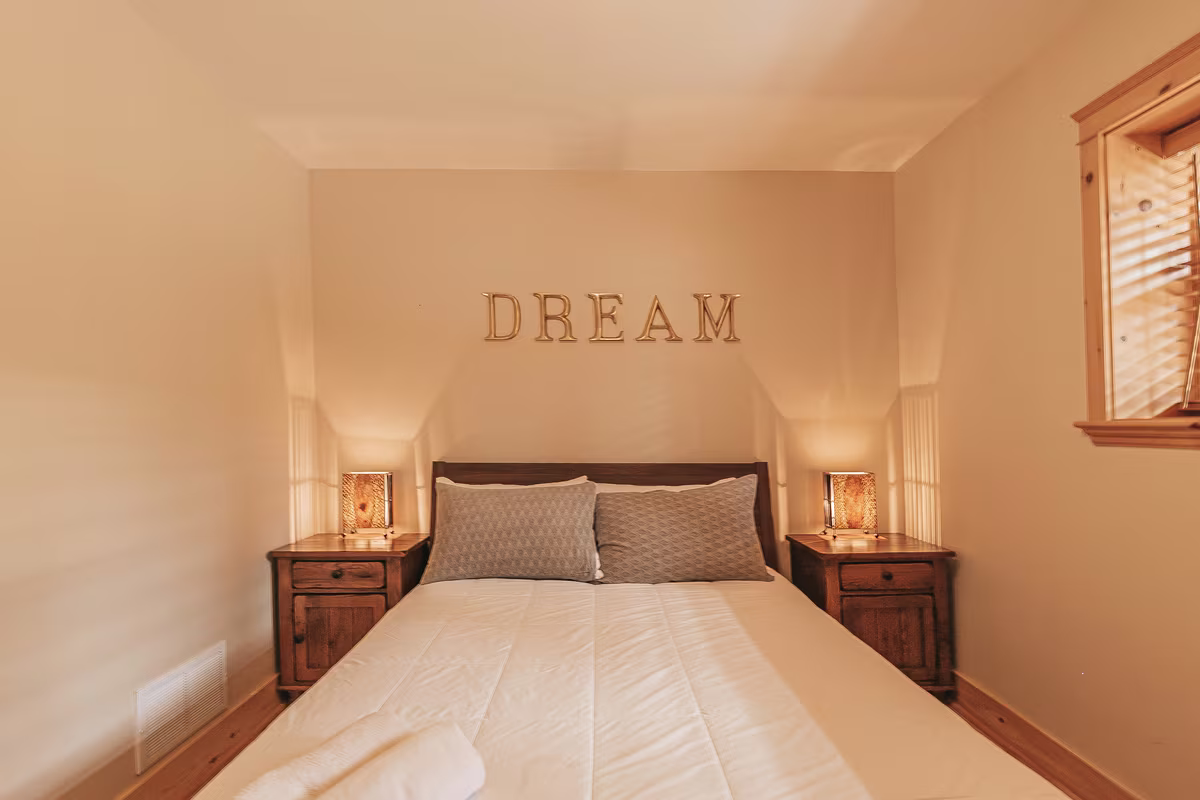 Chambre 3 du chalet Harfang, grand lit sous le mot Dream au mur