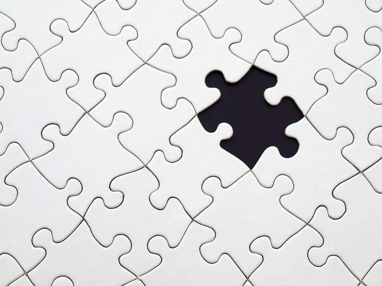 White puzzle with single piece missing from middle