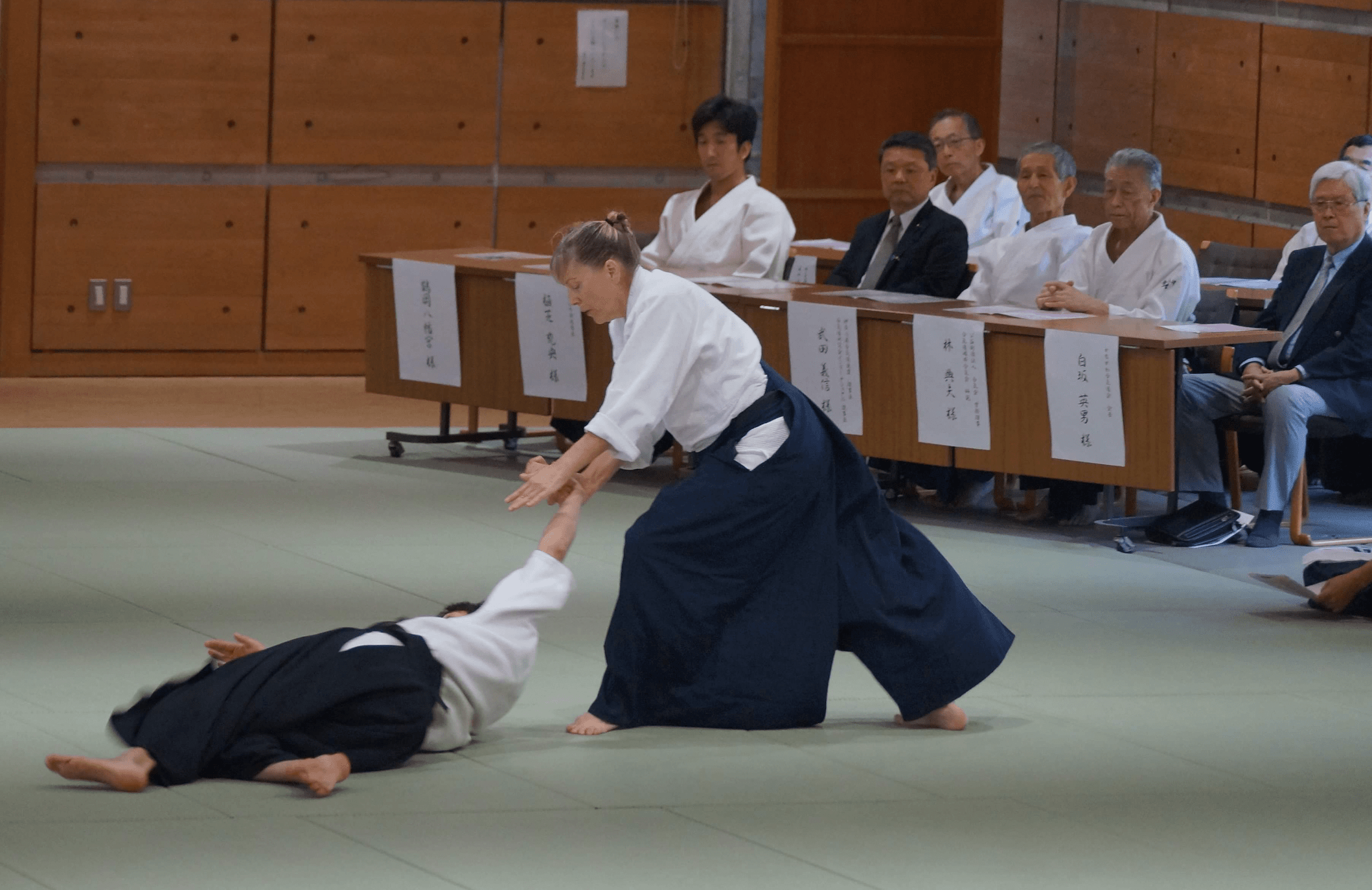 Photo of Lia Suzuki sparring in martial arts in front of a panel of judges