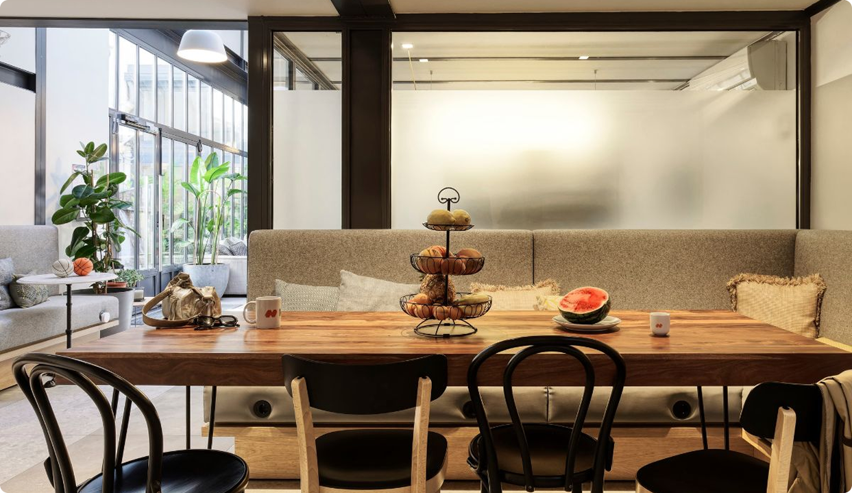 une salle à manger de bureau avec un panier de fruit posé sur la table