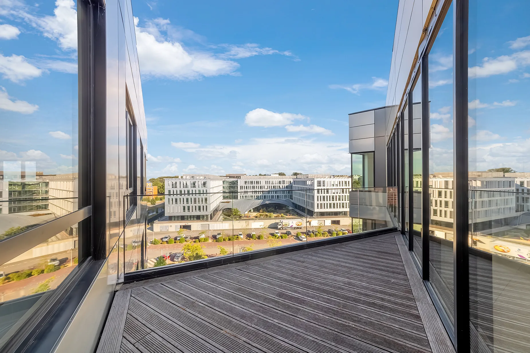 grand espace sans cloisons avec murs blancs et sol en béton, grandes baies vitrées