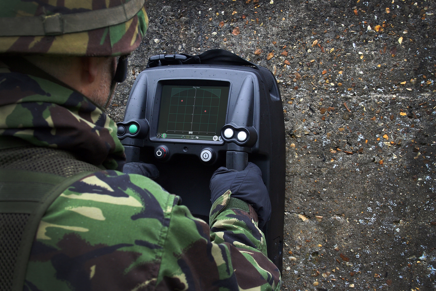 Soldier using a Prism200 through-wall radar unit against a concrete wall