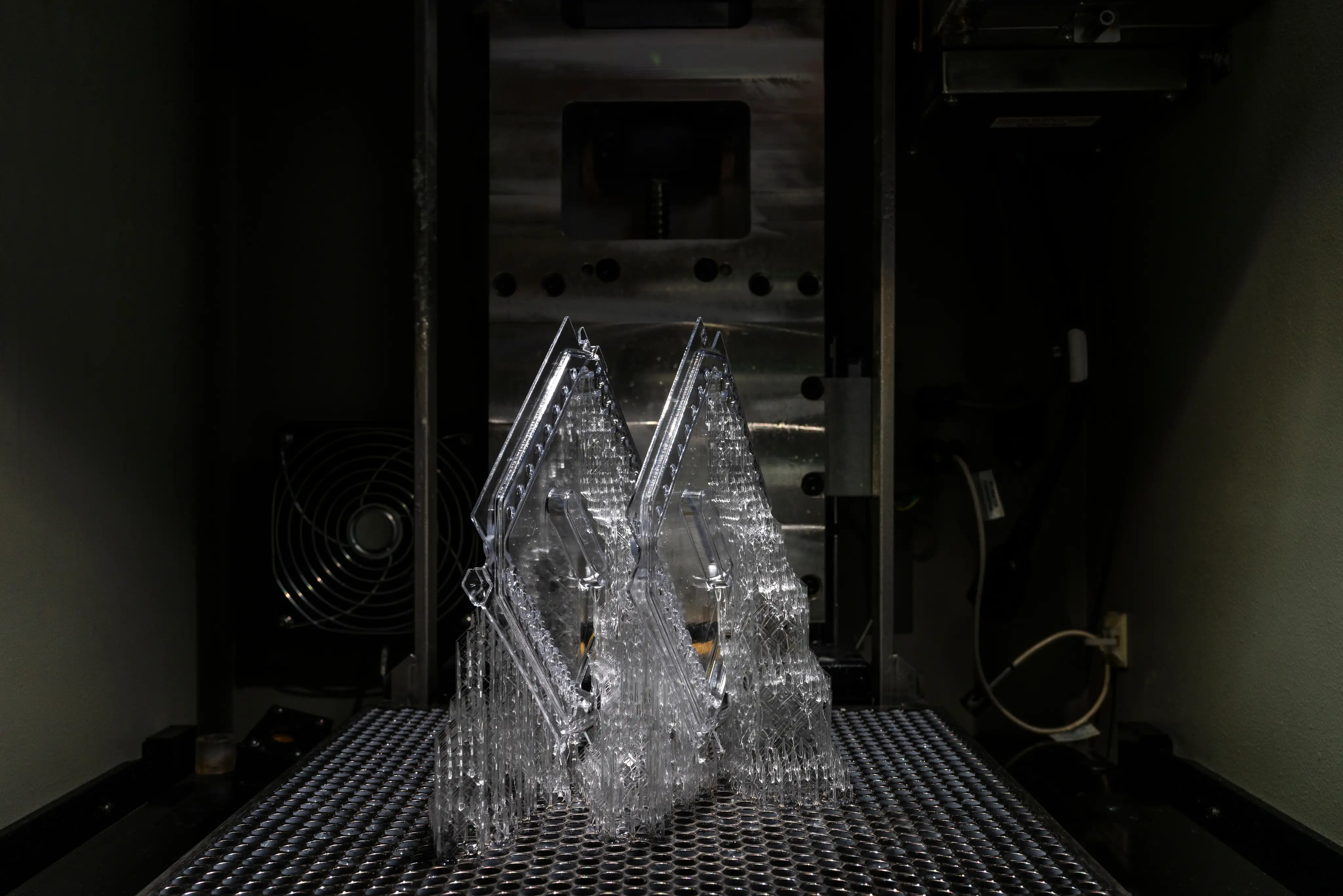 Transparent 3D printed clear SLAplastic objects inside a viper 3D Systems printer.