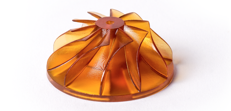 Amber-colored translucent turbine or impeller with curved blades on a white background.