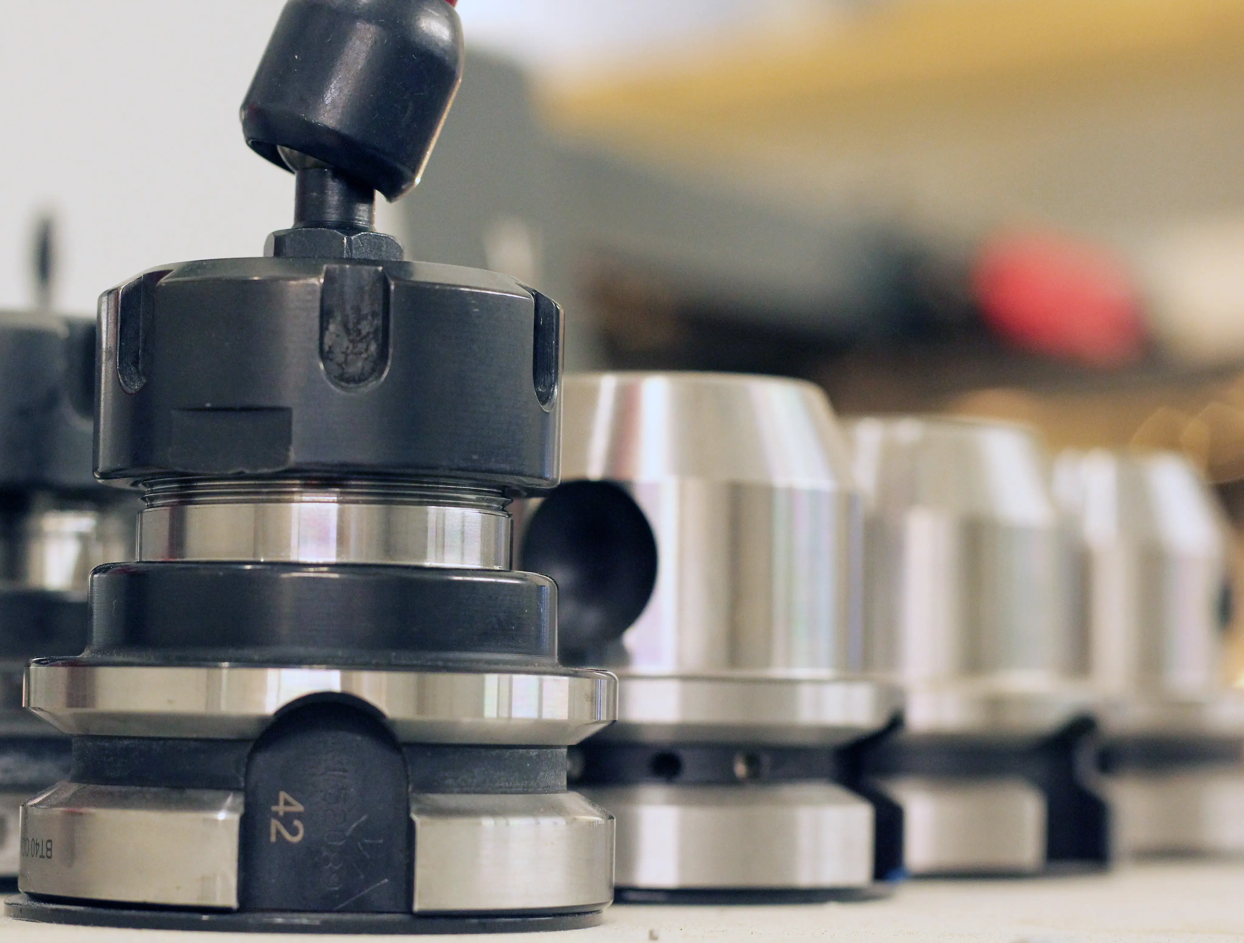 Close-up of a series of metal and black industrial machine tool holders arranged on a shelf.