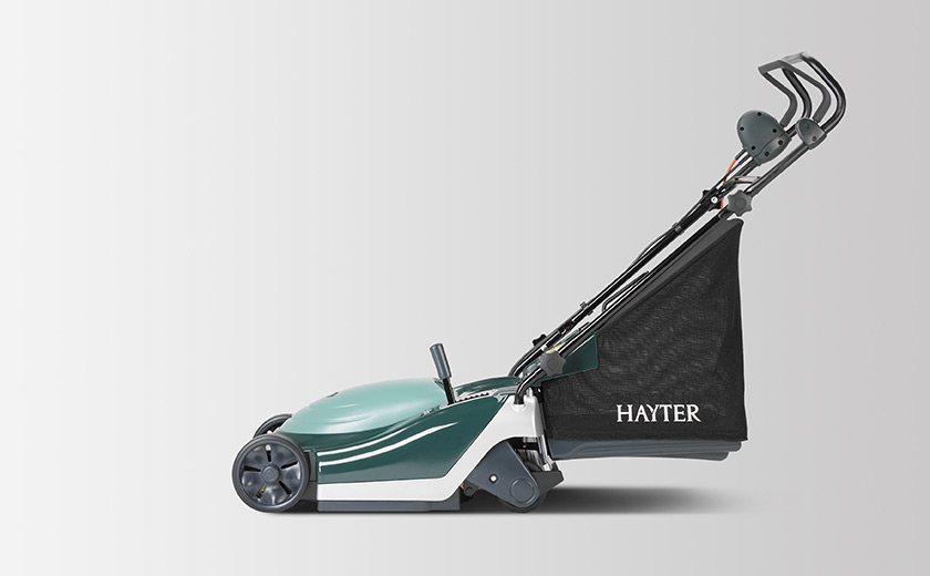 Green and white electric lawn mower with black grass collection bag labeled Hayter.