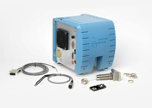 Blue Owlstone ultra FAIMS device with connected cables and small metallic components on a white background.