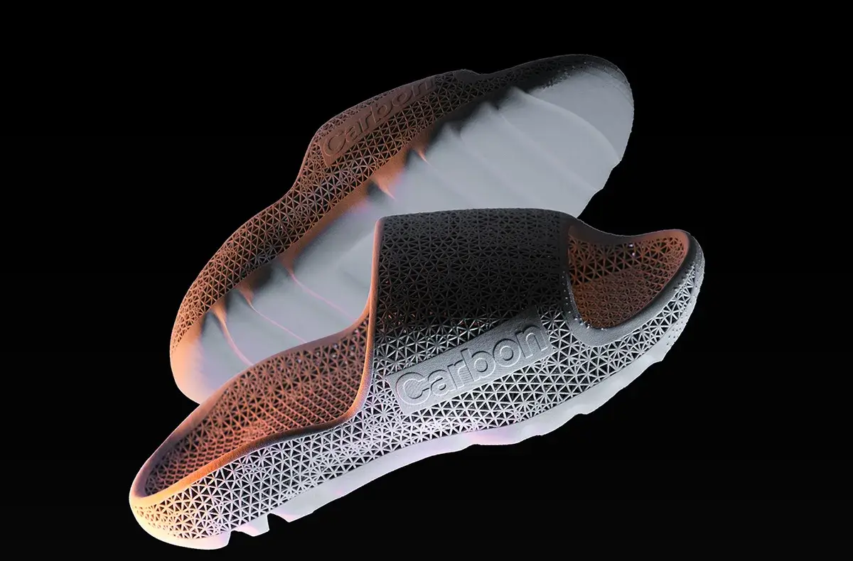 Pair of futuristic slip-on shoes with a lattice carbon fiber structure and the word 'Carbon' on the side.