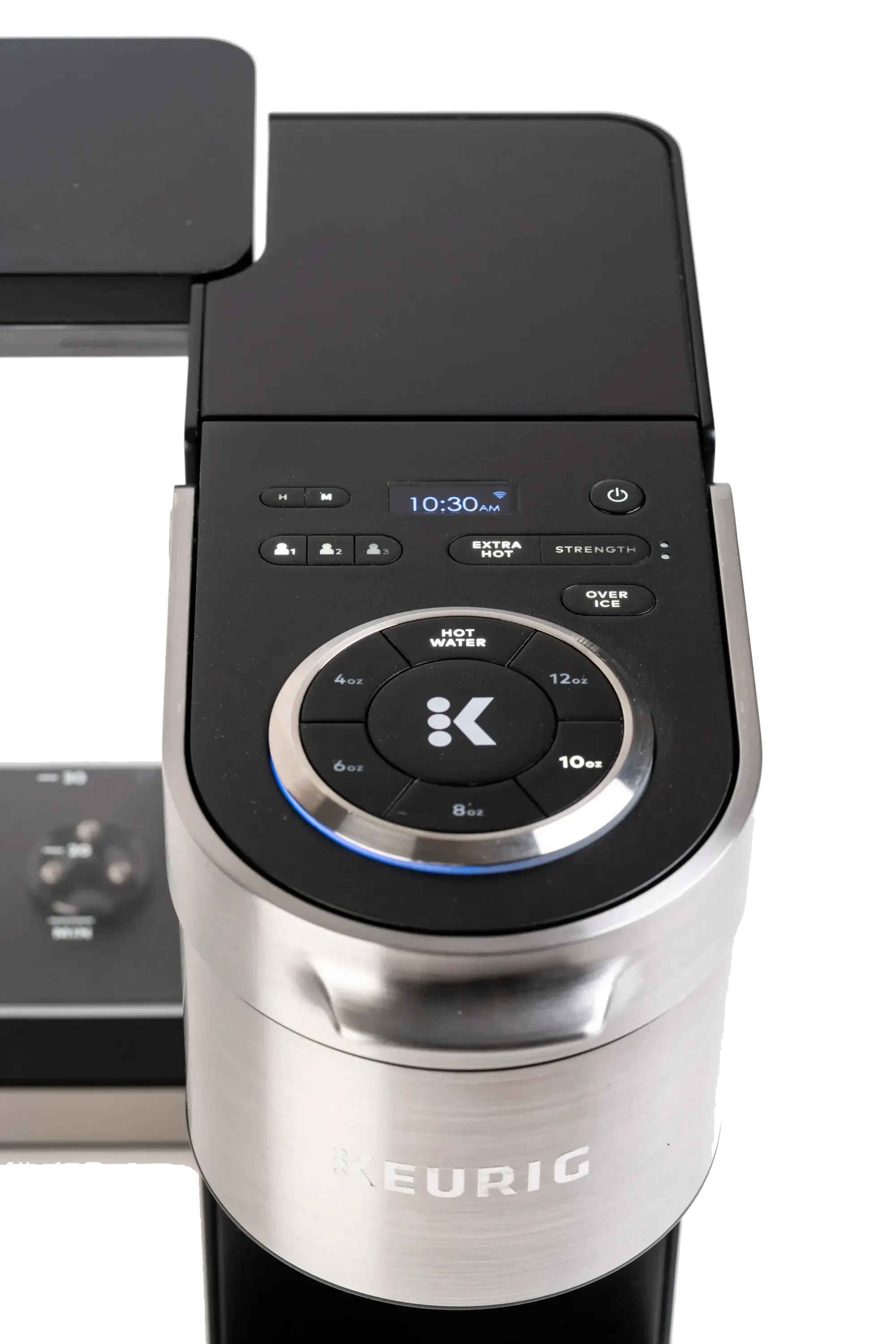 Top view of a Keurig coffee machine control panel displaying time 10:30 AM with buttons for cup size, extra hot, strength, and over ice options.