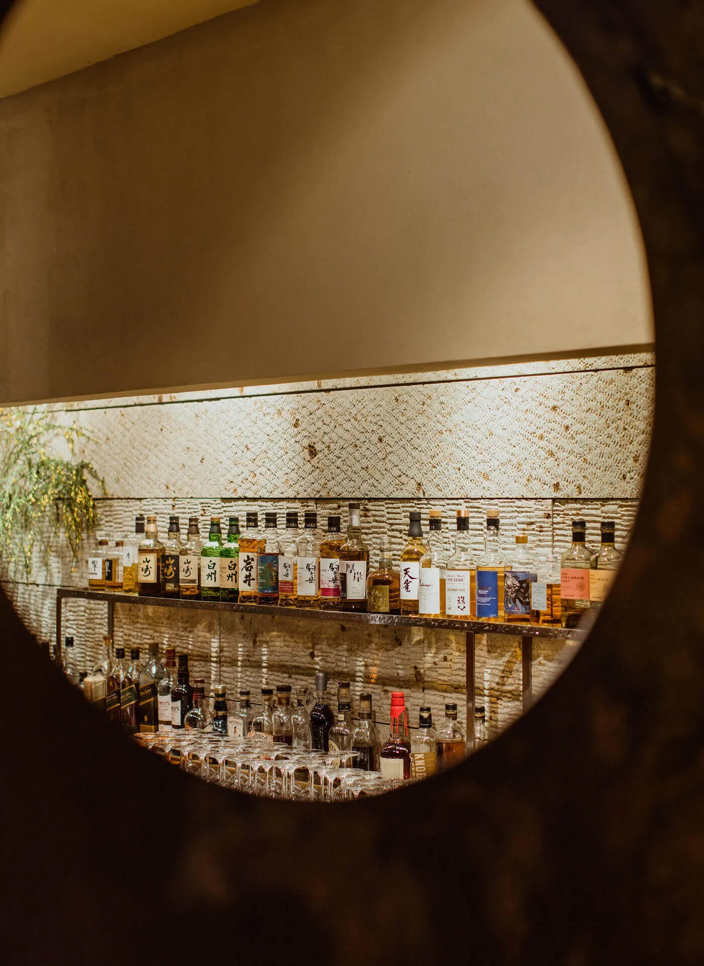 A shot of the bar through the circular hanging wall mirror