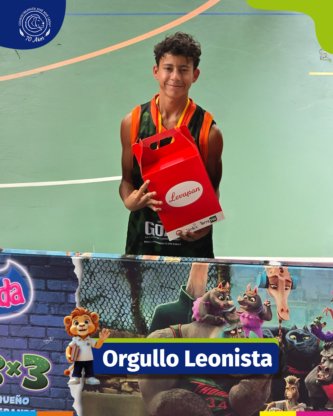 Niño sonriente sosteniendo un trofeo grande en una cancha de tenis de arcilla.