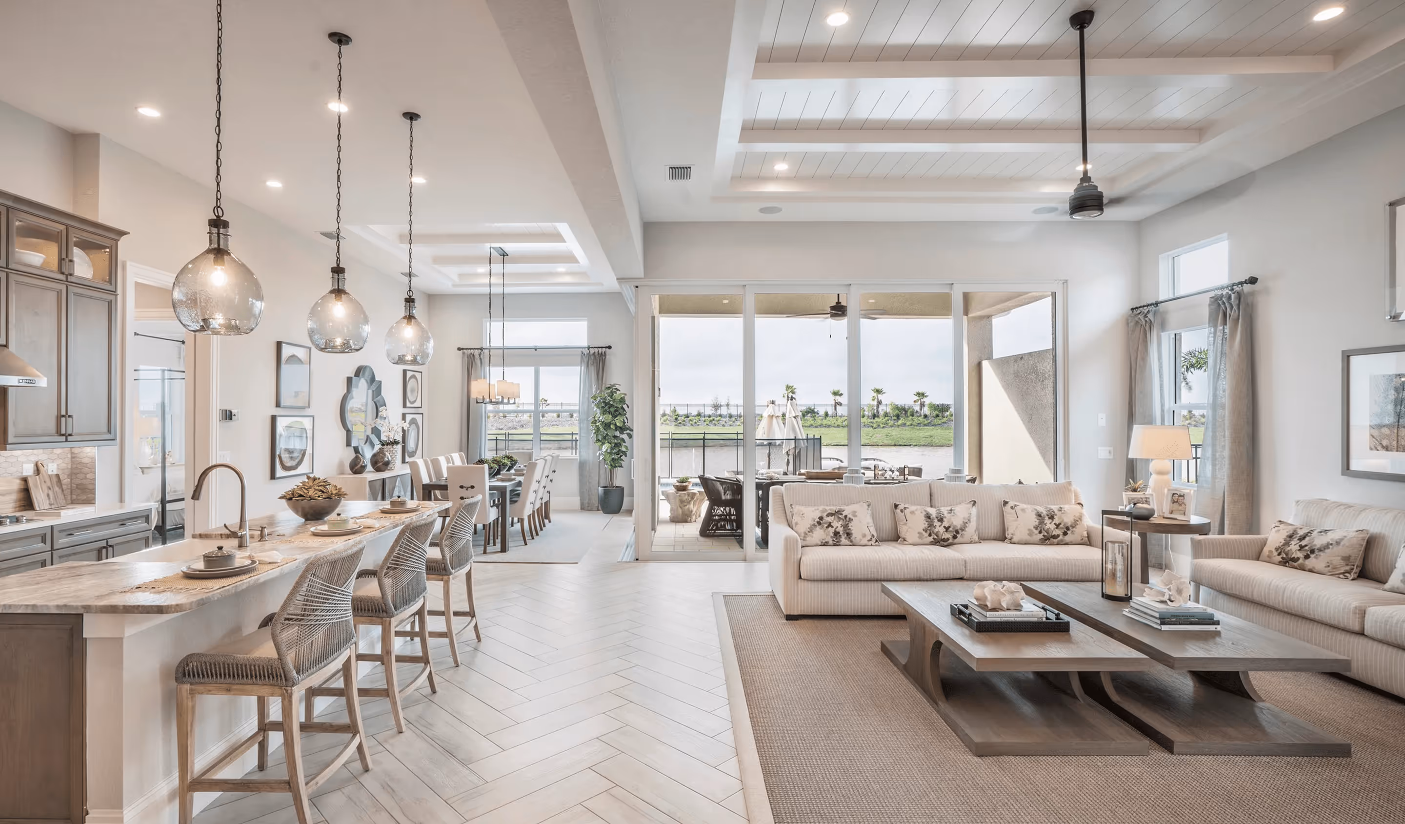Modern open-concept home interior with kitchen island, dining area, and living room overlooking water view - premium home cleaning services St. Johns Ponte Vedra