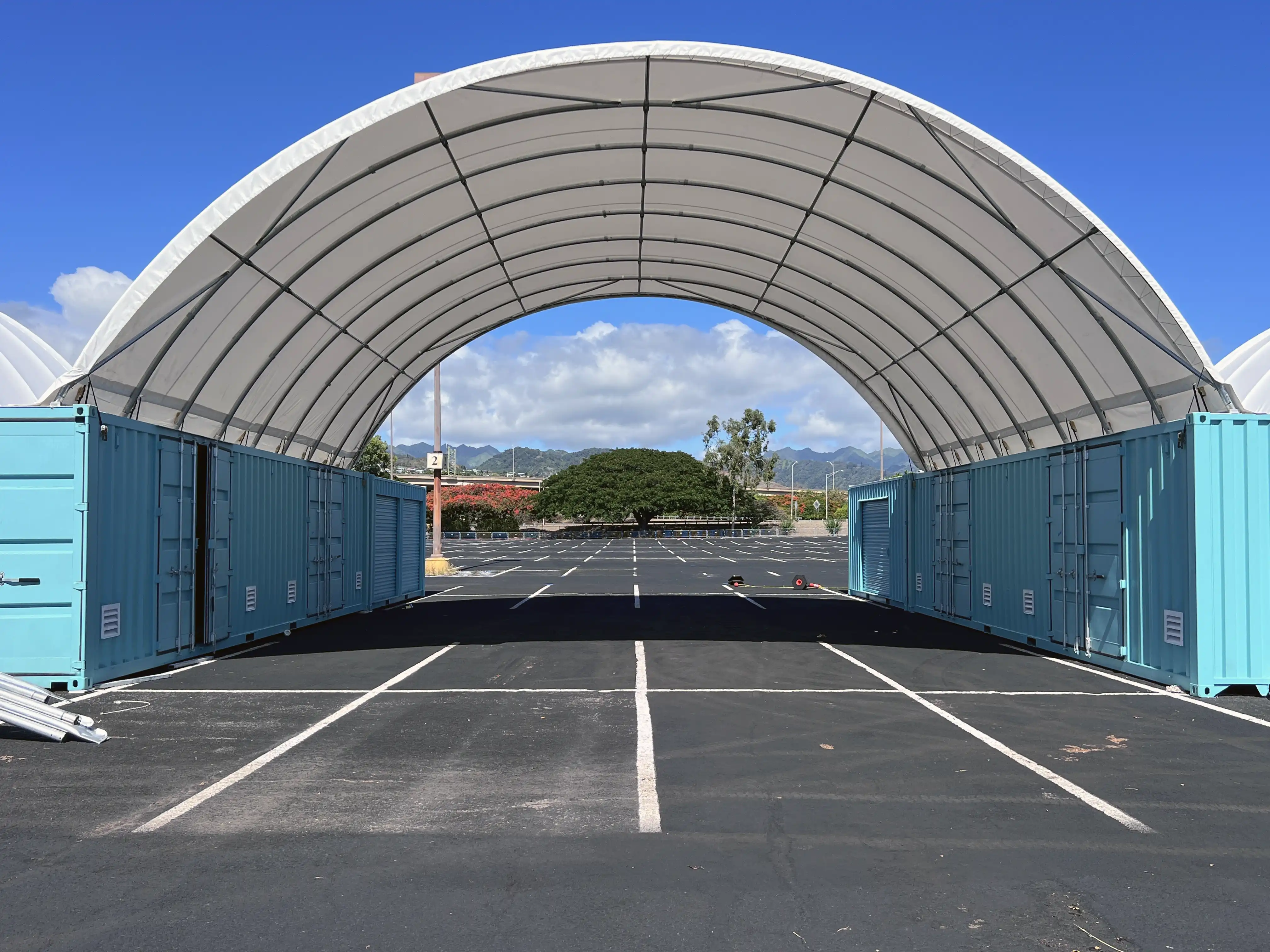 HIWASTE container tent spanning two shipping containers to form a covered warehouse