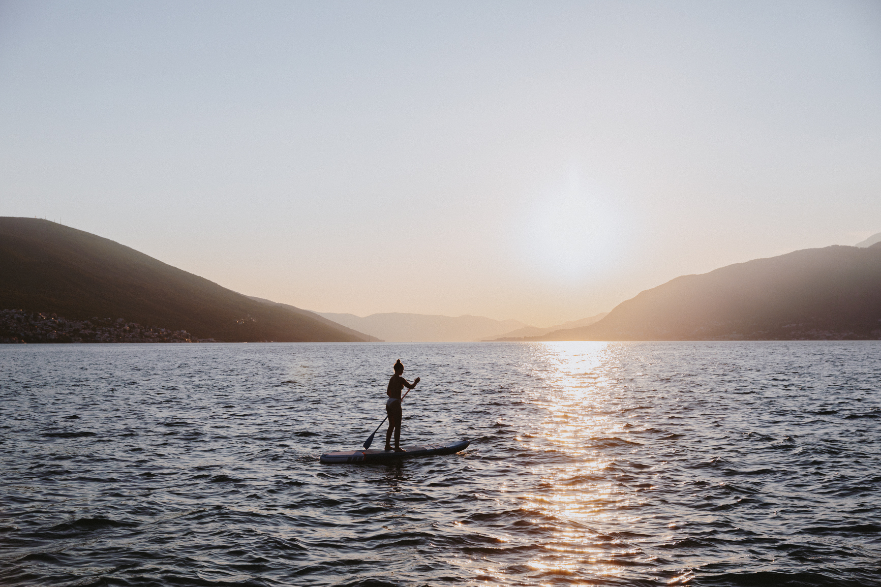 Paddleboarder on a lake at sunset