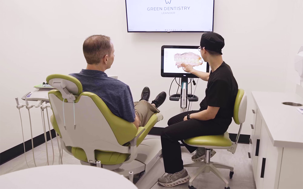 Dentist explaining a dental scan to a patient in a bright dental office.