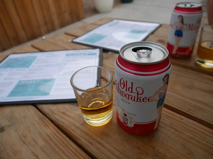 Beer and a shot on a wooden table with menus