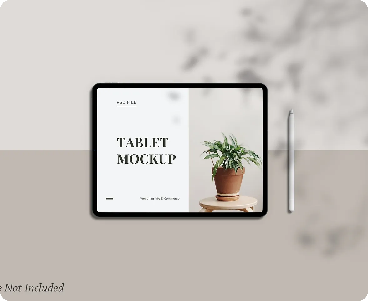 Tablet mockup on a desk beside a potted plant and stylus.