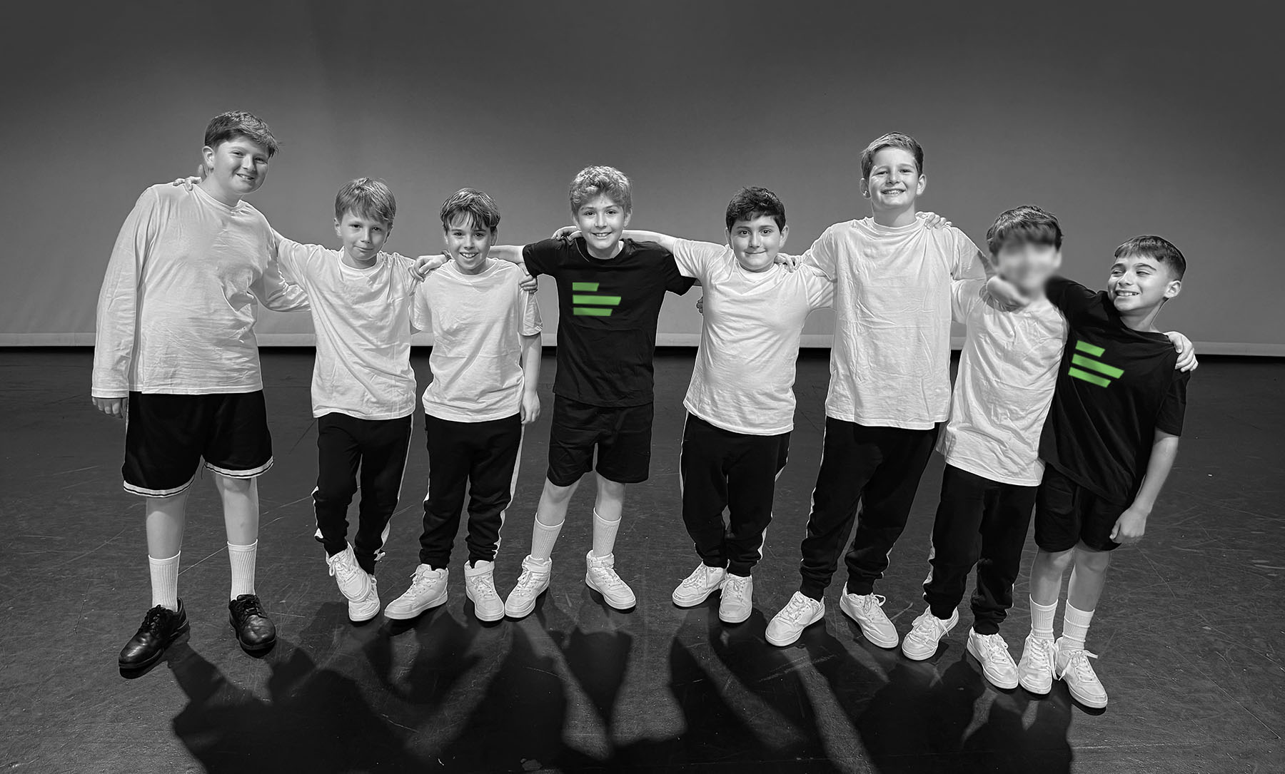 A group of boys standing on a stage smiling