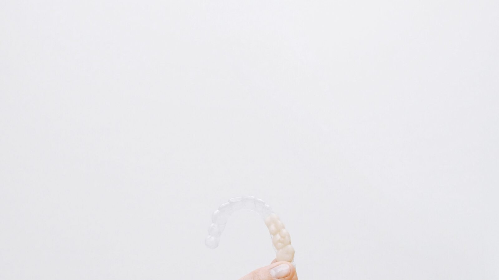 Alineadores transparentes en su estuche abierto sobre una superficie beige minimalista