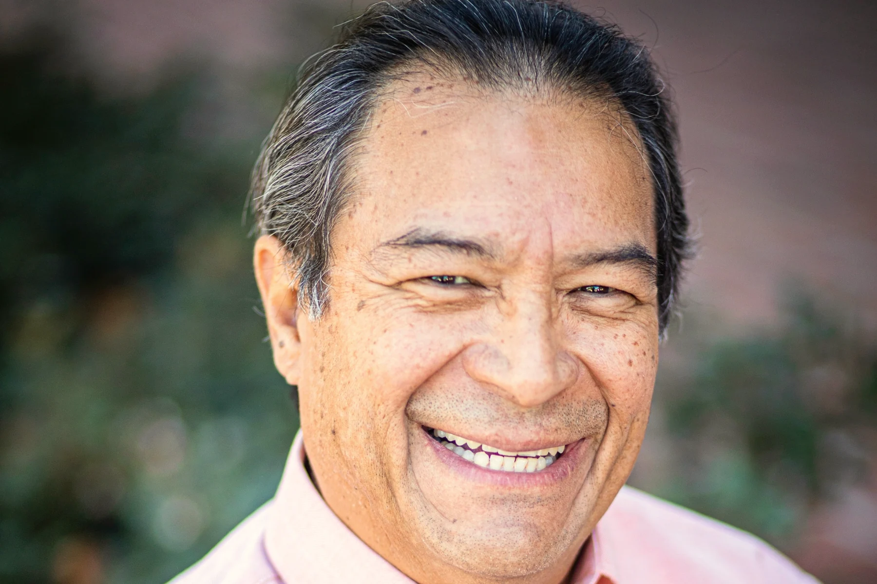 Smiling Latino senior with dentures, Medicare Advantage benefits