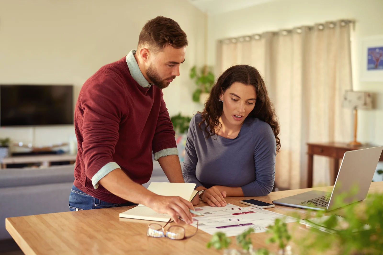 Pareja revisando en casa los papeles de un presupuesto dental