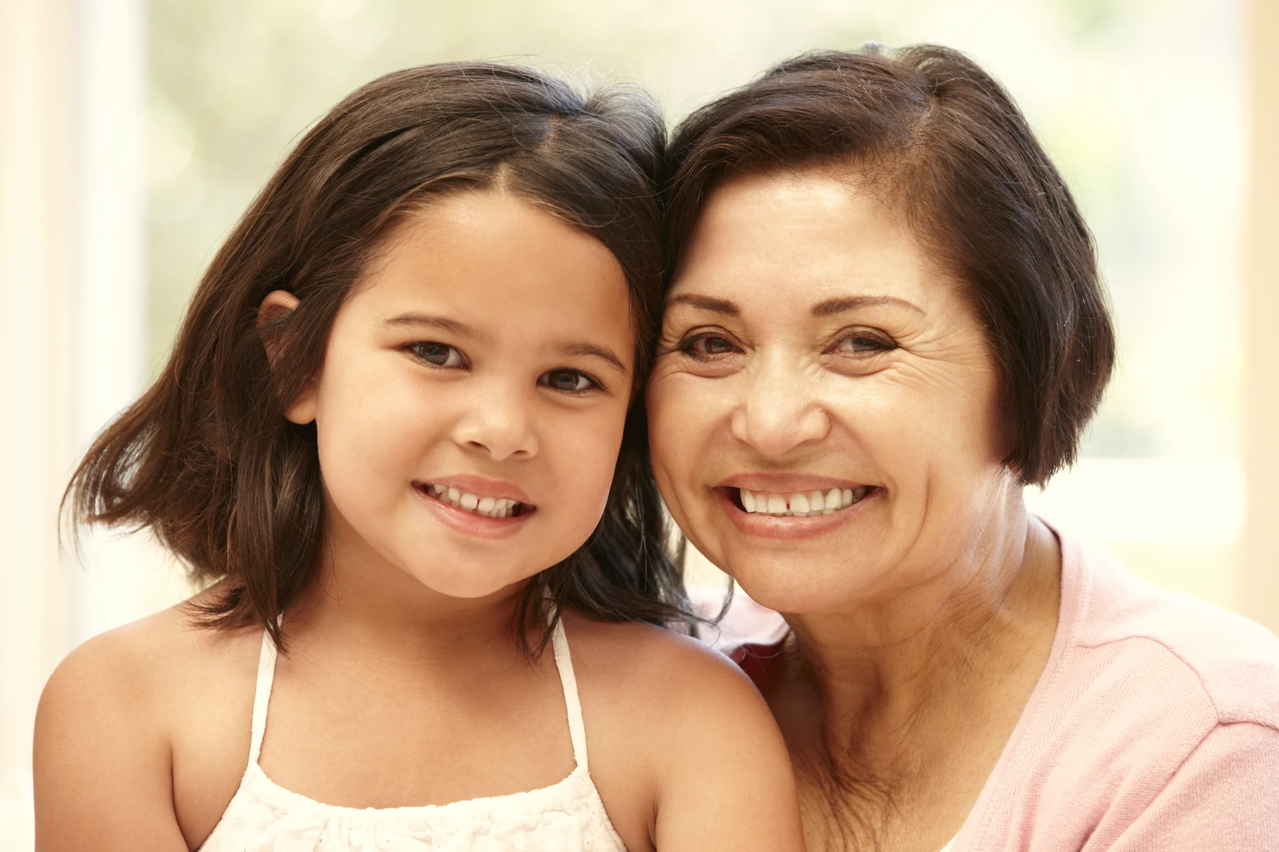 Latina girl and her grandmother smiling before her first dental visit