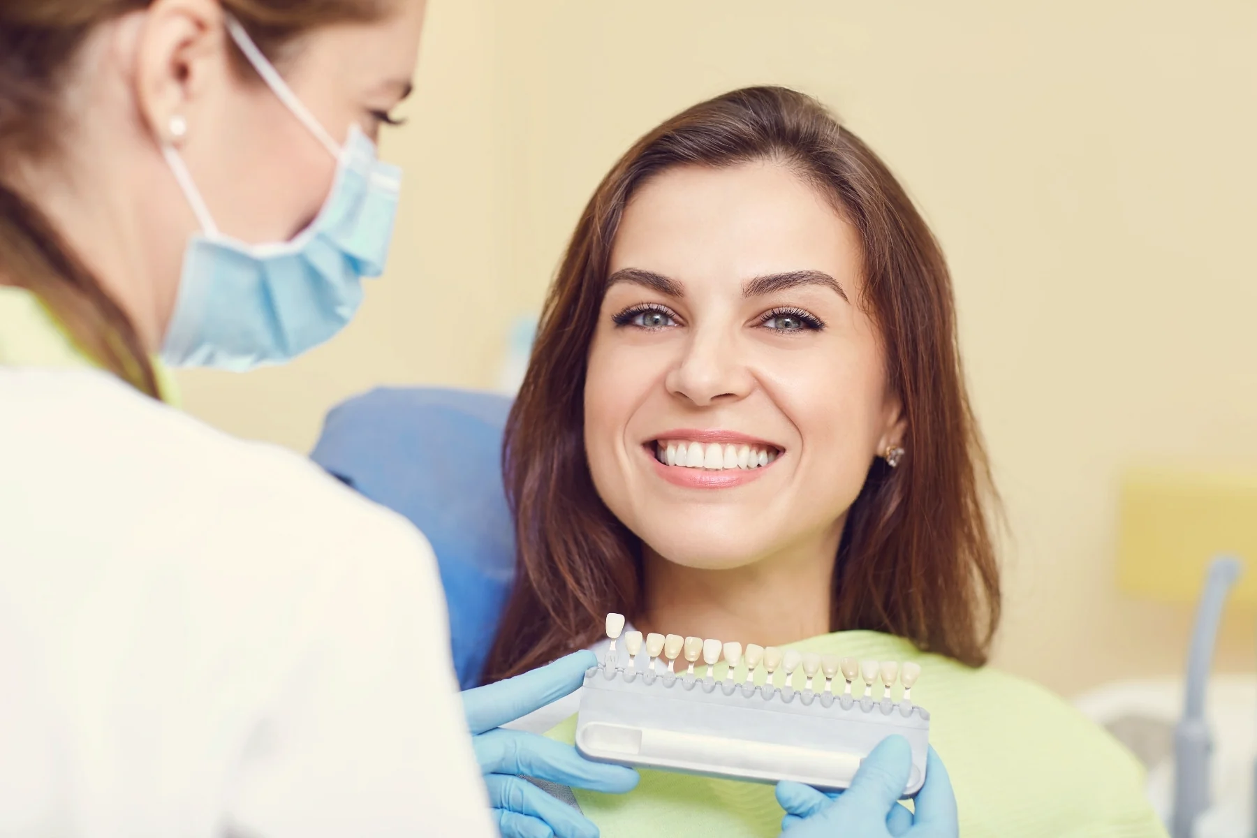Patient comparing her tooth shade with the whitening shade guide