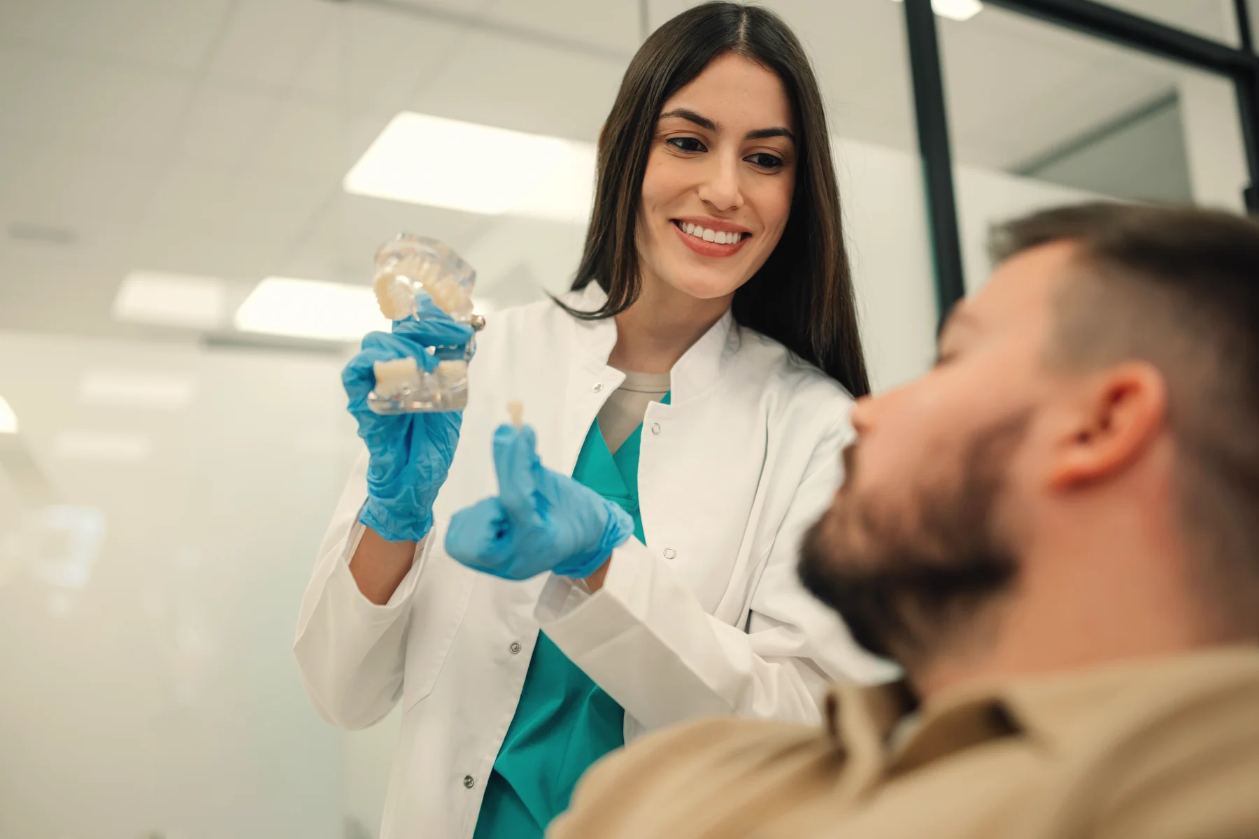 Dentist explaining a dental implant to a patient with a model