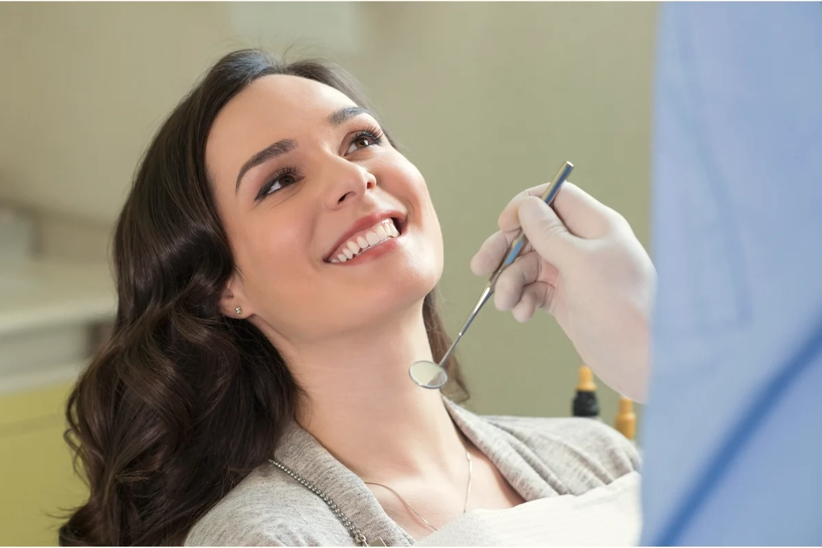 Mujer latina sonriendo durante una revisión dental estética