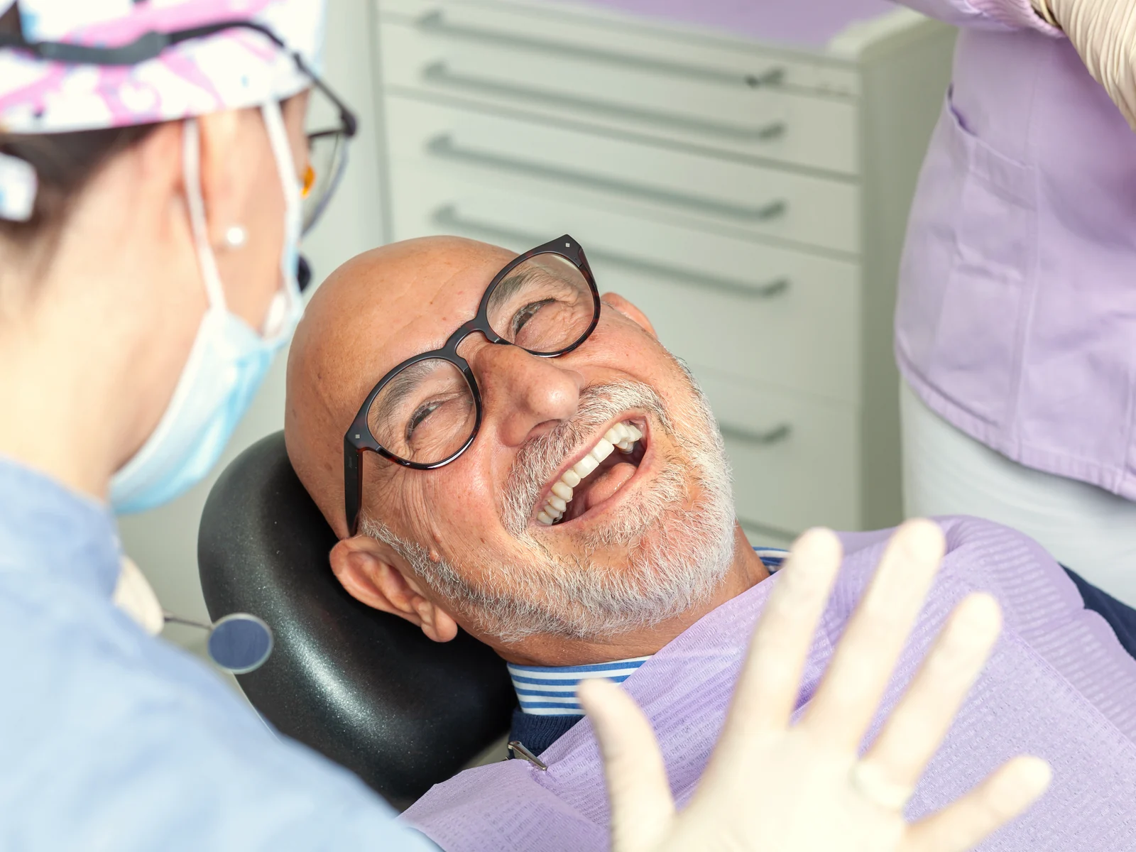 Paciente mayor sonriendo en la consulta dental en Kendall