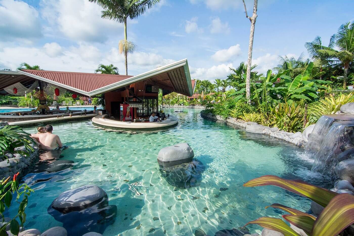 Volcanic hot spring pool surrounded by tropical jungle near Arenal Volcano Costa Rica, illustrating Central American thermal resorts