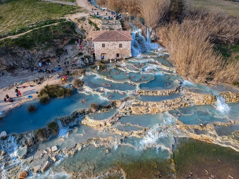 Cascate del Mulino hot spring waterfalls flowing over white travertine in Saturnia Italy, illustrating Italy's natural thermal heritage